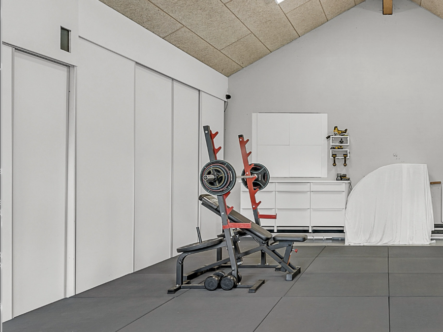 Garage med hvide skydelåger fra gulv til loft langs væggene